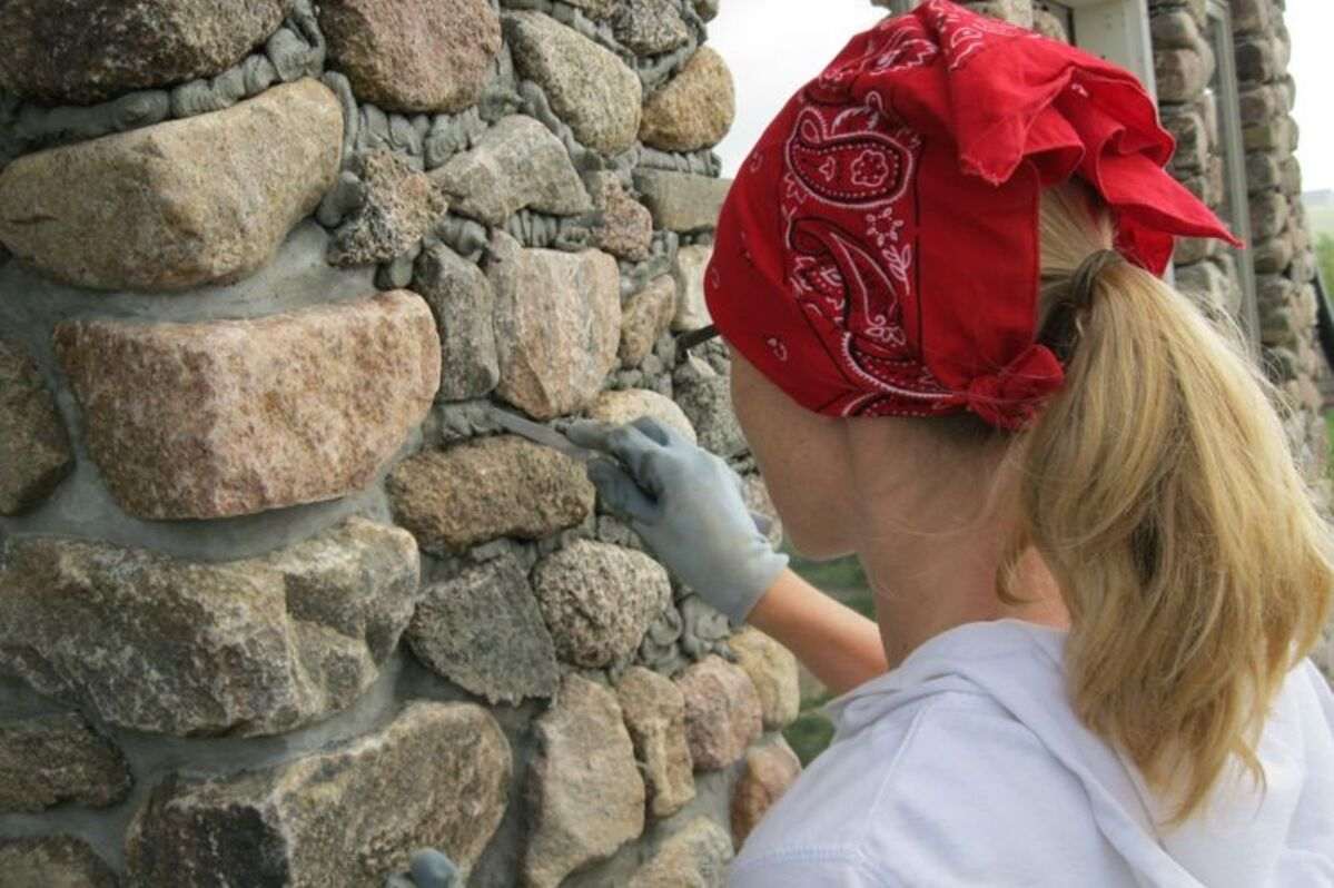 Seorang perempuan sedang melihat pondasi batu kali